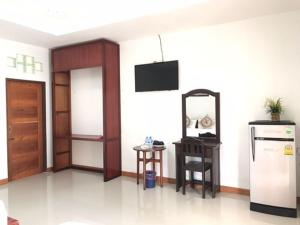 a room with a kitchen with a refrigerator and a table at Vang Vieng Moment Resort in Vang Vieng