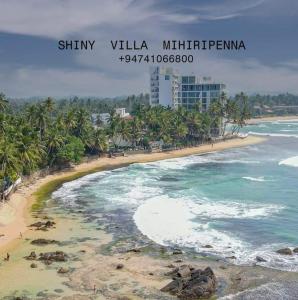 a view of a beach with palm trees and the ocean at Shiny Villa in Unawatuna