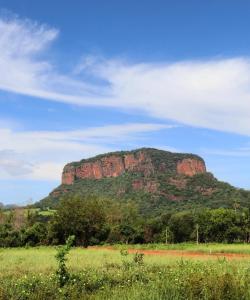 a large mountain in the middle of a field at Chalé em Frente ao Terroir Pantanal in Aquidauana