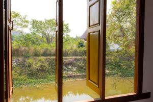 an open window with a view of a flooded field at Vang Vieng Moment Resort in Vang Vieng