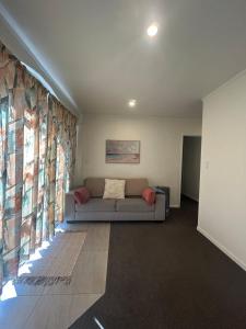a living room with a couch and a large window at Spacious 3-Bedroom Retreat Near Airport & City in Auckland