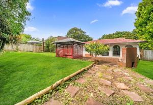 a yard with a house and a fence at Spacious 3-Bedroom Retreat Near Airport & City in Auckland