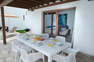 - Sala de estar con mesa de comedor blanca y sillas en Casa Ancoa, en Playa Blanca