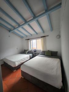 莱瓦镇Hotel Posada Santa María Villa de Leyva的有窗户的房间里有两张床 更多14张照片