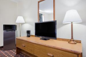 a television on a dresser with a lamp and a mirror at Super 8 by Wyndham Douglas in Douglas