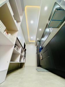 un corridoio con una porta nera e scaffali bianchi di Stylish 3BR Residence - Smart Bath - Cozy Vibes a Lagao III