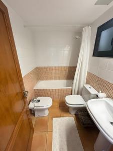 een badkamer met toilet, wastafel en bad bij Duplex Laura in Punta Grossa