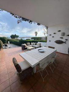 een patio met een witte tafel en stoelen bij Duplex Laura in Punta Grossa