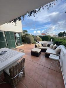 een patio met banken en een tafel en stoelen bij Duplex Laura in Punta Grossa