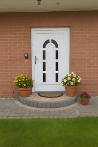 une porte d'entrée d'une maison avec deux pots de fleurs dans l'établissement Ferienwohnung Kijas, à Wismar