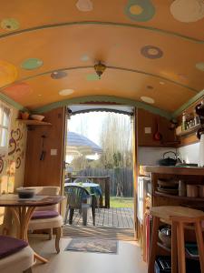 Una cocina y comedor de una casa rodante con una puerta abierta. en La Roulotte Daninas, en Villeneuve-en-Retz