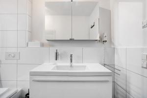 赫汀恩Markgraf Apartments Haus 5的一间白色浴室，配有洗手池和镜子。 更多63张照片