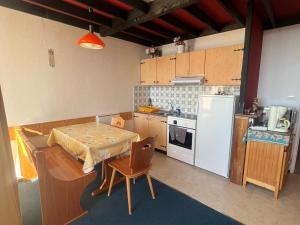 a kitchen with a table and a white refrigerator at Appartement 4 Pers au Cœur de Super Besse - FR-1-814-142 in Super Besse +5 photos