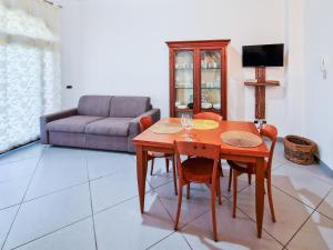 un soggiorno con tavolo, sedie e divano di Villa Corallo ad Alghero