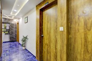 ein Flur mit einer Holztür und einer Topfpflanze in der Unterkunft Hotel O Bhavy in Ahmedabad + 22 Fotos