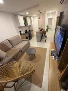 a living room with a couch and a tv at Vivo Costanera Apartamento Frente a la playa San José de Encarnación! in Encarnación