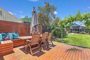 a patio with a table and an umbrella at Home at Haverfield in Echuca