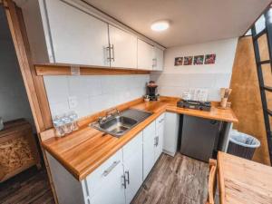 una cucina con lavandino e piano di lavoro in legno di BosqueCielo Cabañas Diseño Natural Arte Galeria a Huasca de Ocampo Altre 24 foto