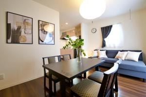 a living room with a table and a blue couch at Chill Place 125 Kameari in Tokyo