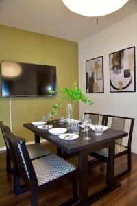 a dining room with a table with chairs and a tv at Chill Place 125 Kameari in Tokyo