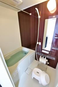 a bathroom with a tub and a toilet and a mirror at Chill Place 125 Kameari in Tokyo +63 photos