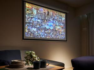 een televisiescherm met een groot beeld aan de muur bij Minn Umeda Nakazakicho in Osaka