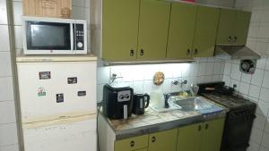 a small kitchen with a sink and a microwave at a TRES MIN DEL CENTRO in Concordia