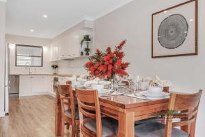 ein Esszimmer mit einem Tisch und Stühlen mit roten Blumen in der Unterkunft Campaspe Central - Your Central Echuca Escape! in Echuca