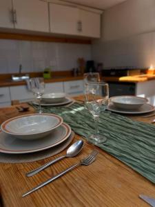 a table with plates and glasses and silverware on it at BosqueCielo Cabañas Diseño Natural Arte Galeria in Huasca de Ocampo +36 photos
