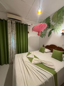 a bedroom with a bed with a pink umbrella at Goalma Family Holiday Resort & Restaurant in Anuradhapura