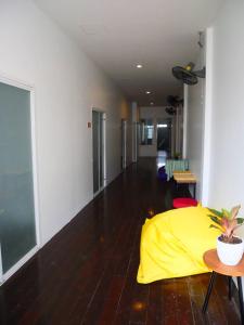 a living room with a yellow cover on the floor at RYB Hostel Phuket in Ban Lo Long
