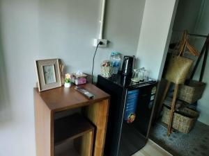 a kitchen with a black refrigerator and a wooden table at Baan Boy in Ko Kood
