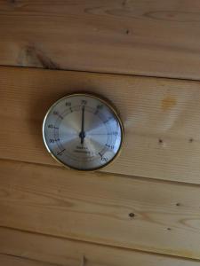Eine Uhr hängt an einer Holzwand in der Unterkunft Forest Hillside Cabin Tarcin in Tarčin