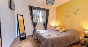 een slaapkamer met een bed, een spiegel en een raam bij Villa Flora in Balazuc +16 foto's