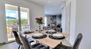 een eetkamer met een houten tafel en stoelen bij Villa Flora in Balazuc