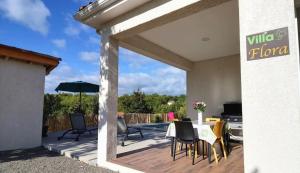 een terras met een tafel, stoelen en een parasol bij Villa Flora in Balazuc