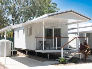 a tiny house with a porch and a deck at The Mill Inn Tavern in Millmerran