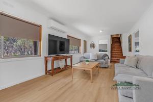a living room with a couch and a tv at Echuca 265 - Echuca Holiday Homes in Echuca +12 photos