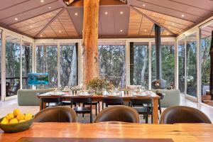 ein Esszimmer mit Tischen und Stühlen und Fenstern in der Unterkunft The Treehouse in Moama