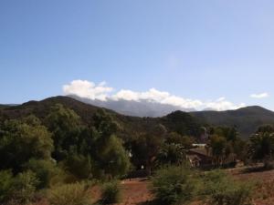 a view of the mountains with a house and trees at Emma's Place in De Rust +10 photos