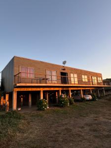 a large brick building with a balcony on it at Cabañas Mc Chelo in Pelluhue