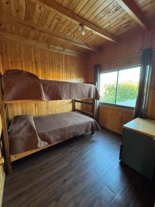 a bedroom with a bed and a window in a cabin at Cabañas Mc Chelo in Pelluhue