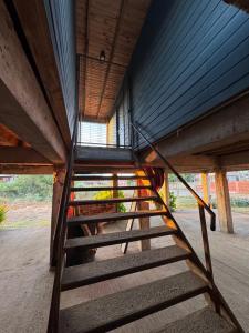 a wooden staircase in a building with a window at Cabañas Mc Chelo in Pelluhue +2 photos