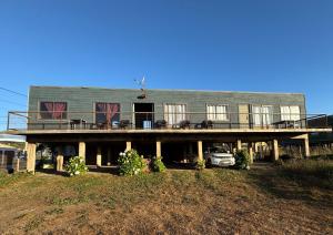 a house with a deck and a car parked in front at Cabañas Mc Chelo in Pelluhue