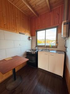 a kitchen with a stove and a sink in a room at Cabañas Mc Chelo in Pelluhue