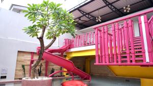 a pink slide in a building with a tree at Luxury Malioboro Hotel in Yogyakarta