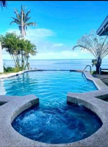 a swimming pool with a view of the ocean at French Panorama Resort in Dauis