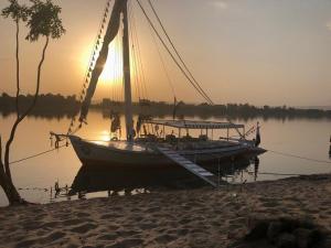 a boat is docked on the water near a beach at Humpty Dumpty in Luxor