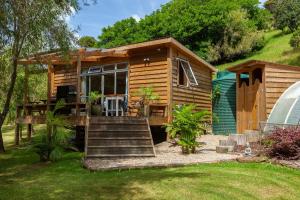 Totara NorthSub-Tropical Paradise Retreat Willow Creek Cabin with Access to Sauna的一个小木屋,设有通往小屋的楼梯