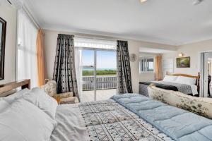 a bedroom with a large bed and a balcony at No 1 Beachfront Holiday Home in New Plymouth